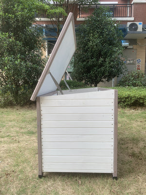 White outdoor storage unit with a slanted lid on grass at Pet Servo