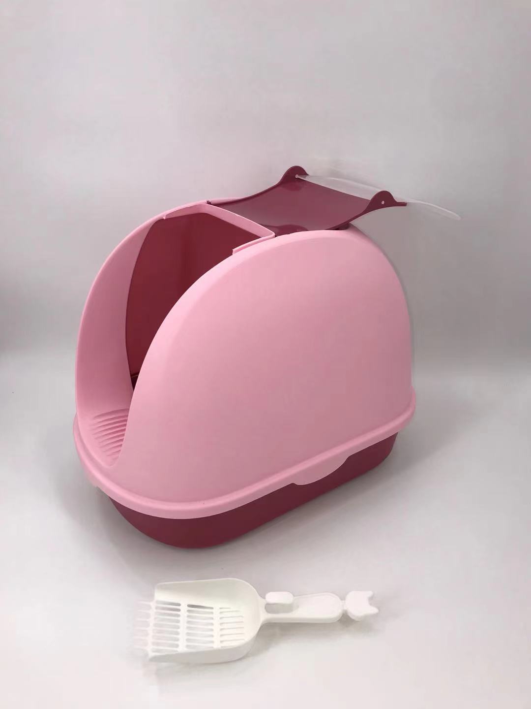 Pink and red pet litter box with a white scoop on a light gray background at Pet Servo