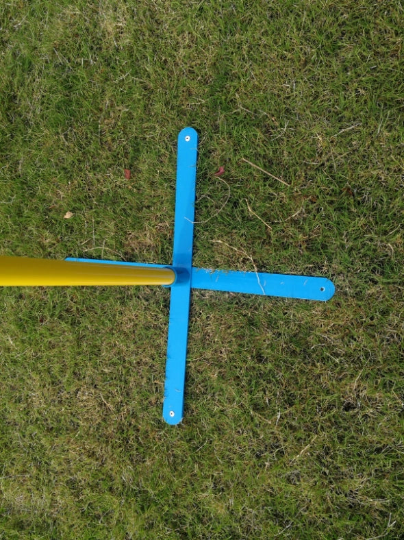 Yellow and blue cross-shaped object on grass at Pet Servo