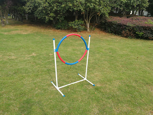 Red and blue hoop on a stand in a grassy area with trees in the background at Pet Servo