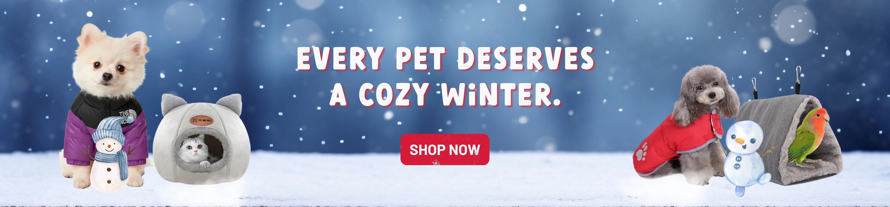 A festive winter promotional banner for pet accessories. The scene shows two small dogs in a snowy setting with cozy items: a white dog on the left wearing a black sweater and purple scarf, standing next to a gray cat-shaped pet bed with a cat inside, and a gray dog on the right wearing a red sweater next to a small white snowman and a gray pet tent.