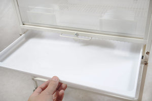 Hand opening a white cabinet door with a textured wall in the background at Pet Servo