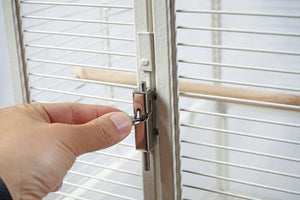 Hand opening a birdcage door with a latch at Pet Servo
