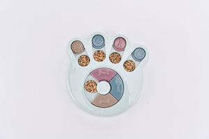 Paw-shaped pet treat dispenser with various treats on a light gray background at Pet Servo