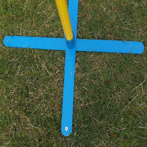A close-up of a blue cross-shaped metal frame with a yellow vertical pole, placed on a patch of green grass at Pet Servo