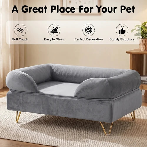 A gray velvet pet bed with gold metal legs, shown in a styled room setting with a beige rug and wooden side table. The image includes a text banner at the top reading 'A Great Place For Your Pet' and four feature icons for 'Soft Touch', 'Easy to Clean', 'Perfect Decoration', and 'Sturdy Structure' at Pet Servo
