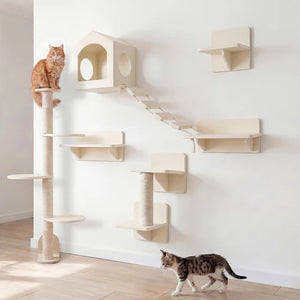 A wall-mounted cat tree set in a bright room, featuring multiple platforms, a climbing ladder, a house-shaped perch, and a sisal-wrapped post. An orange tabby cat sits on the left post, and a brown-and-white cat walks across the light wood floor below at Pet Servo
