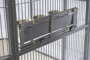 Close-up of a metal pet enclosure or cage with a textured dark gray panel and two stainless steel bowls mounted on the side at Pet Servo