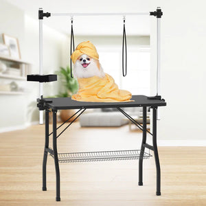 Dog draped in a yellow towel on a grooming table with a white background at Pet Servo