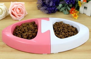 Heart-shaped pink and white pet food bowl with pet food on a wooden surface with flowers in the background at Pet Servo