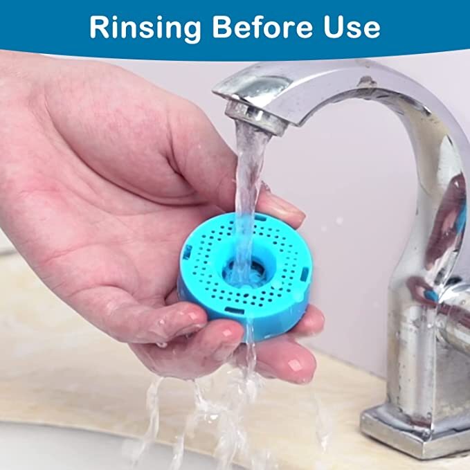 Hand rinsing a blue shower filter under running water from a faucet at Pet Servo