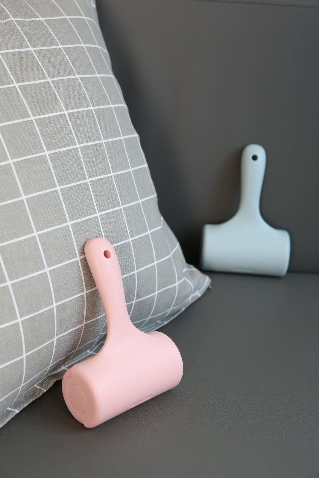 Pink and light blue pet grooming tools on a dark surface with a gray pillow in the background at Pet Servo