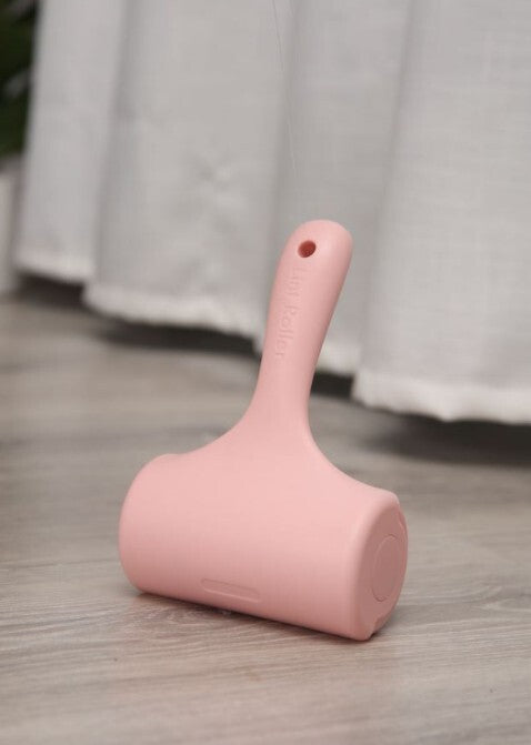 Pink cleaning tool on a wooden floor with white curtains in the background at Pet Servo
