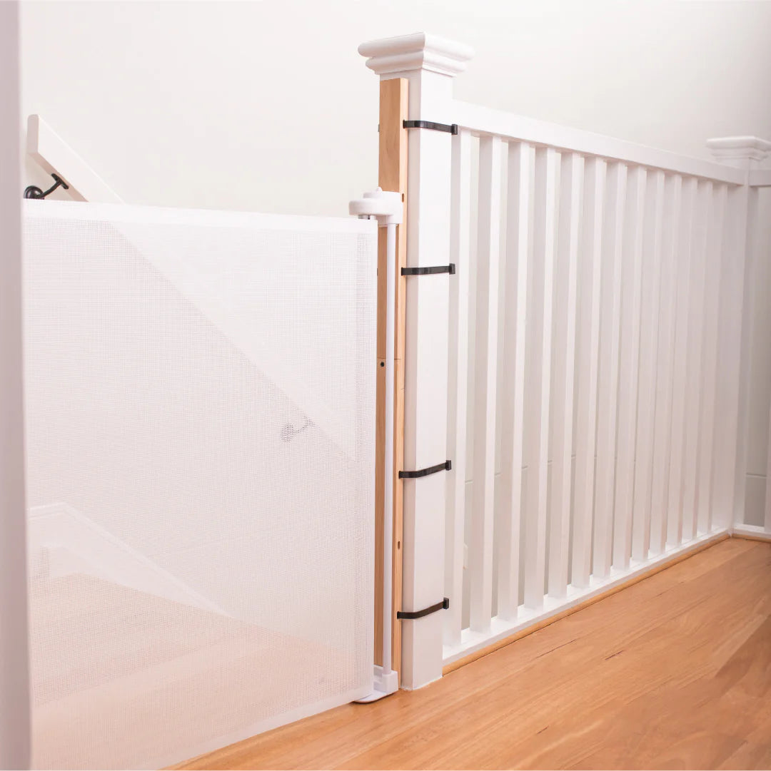 Wooden staircase with white balusters and wooden handrail in a home interior.