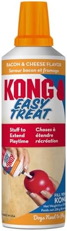 A can of Kong Easy Treat Stuff to Extend Playtime, in bacon and cheese flavor. The white plastic can features a bright orange spray nozzle, with red and blue branding text and an illustration of a hand holding a red apple at Pet Servo