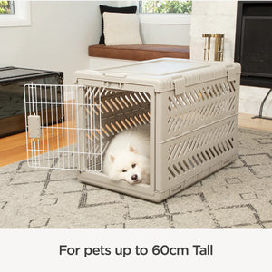 Dog crate with a white dog inside in a living room setting
