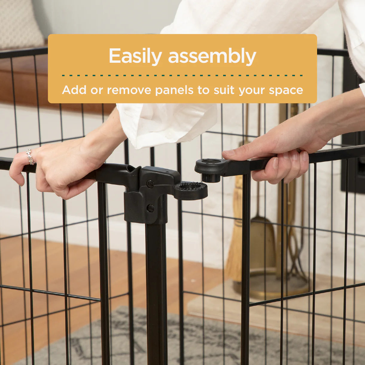 Person assembling a black metal gate with text overlay on a neutral background