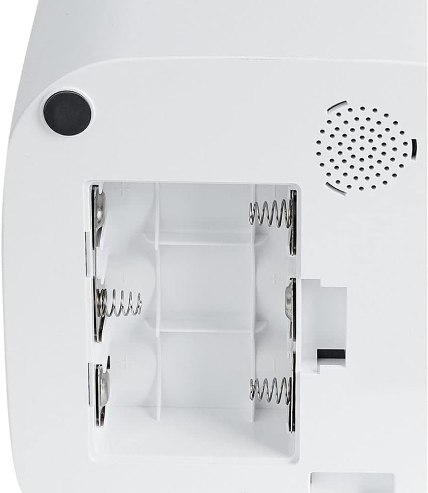 Close-up of the back of a white electronic device showing the battery compartment with exposed spring contacts and a circular speaker grille at Pet Servo