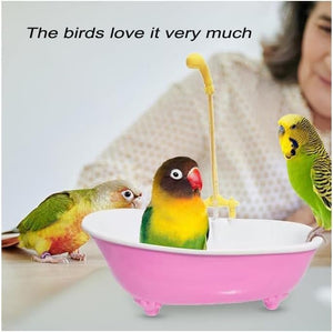 Three colorful parakeets in a small pink bathtub with a yellow shower head, and a person in the background at Pet Servo