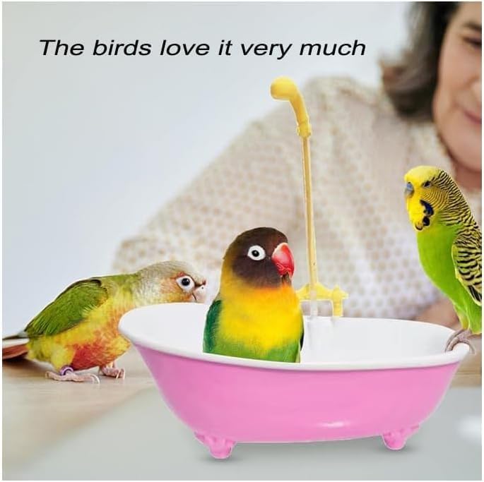 Three colorful parakeets in a small pink bathtub with a yellow shower head, and a person in the background at Pet Servo