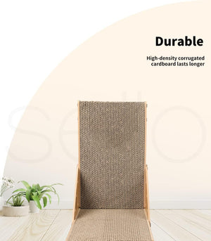 A tall cat scratching post with a textured sisal-wrapped back and a natural wood base, shown in a clean interior setting with small potted plants and text reading 'Durable' and 'High-density corrugated cardboard lasts longer' at Pet Servo