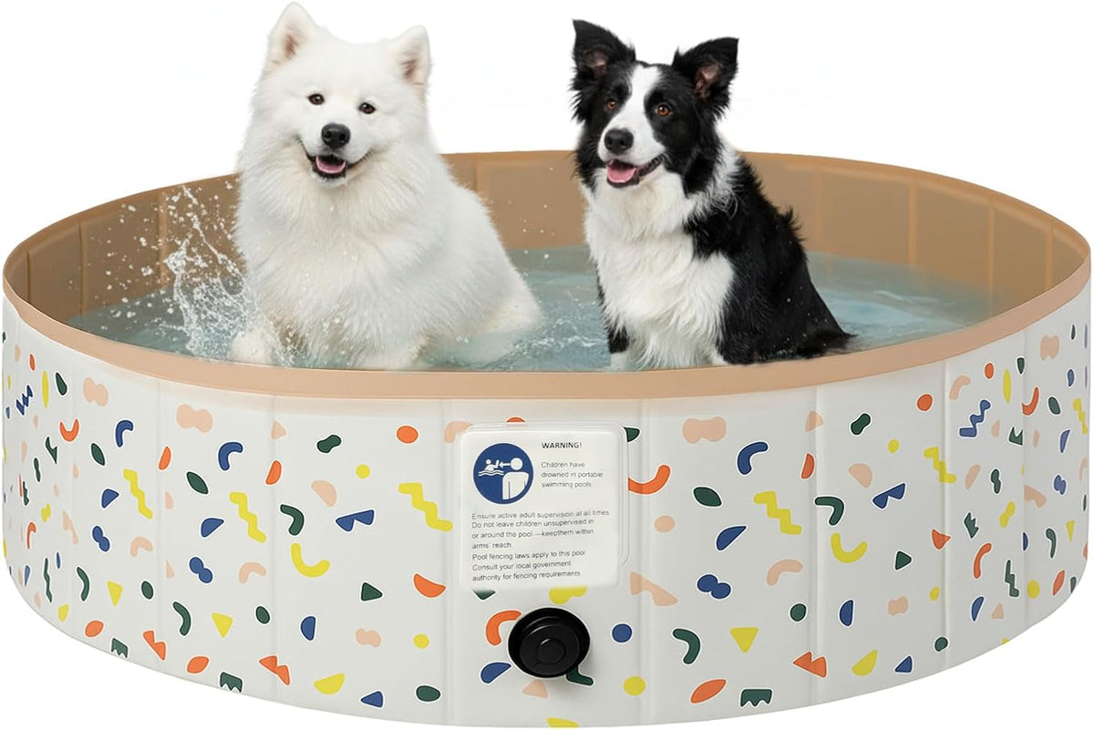 Two dogs sitting in a circular inflatable pet pool with a white exterior decorated with multicolored confetti-like shapes, on a plain white background.