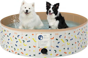 Two dogs sitting in a circular inflatable pet pool with a white exterior decorated with multicolored confetti-like shapes, on a plain white background.