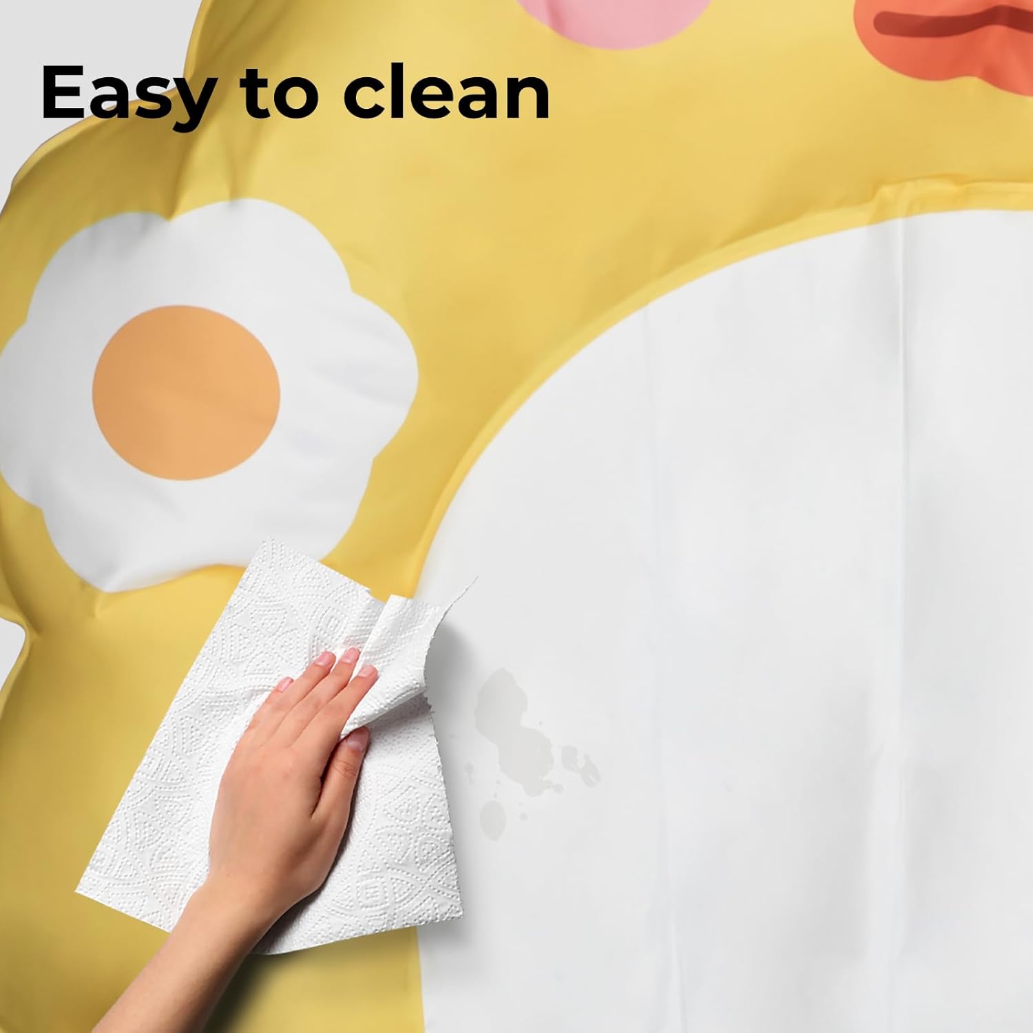 A close-up of a yellow and white patterned surface with a hand wiping it with a paper towel. The text 'Easy to clean' appears at the top, and the surface has a printed egg design at Pet Servo