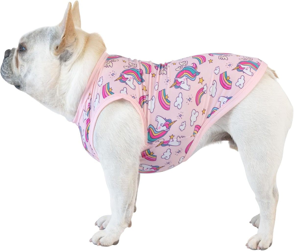 A white French Bulldog wearing a pink pet harness with a colorful unicorn and rainbow pattern, shown against a plain white background at Pet Servo