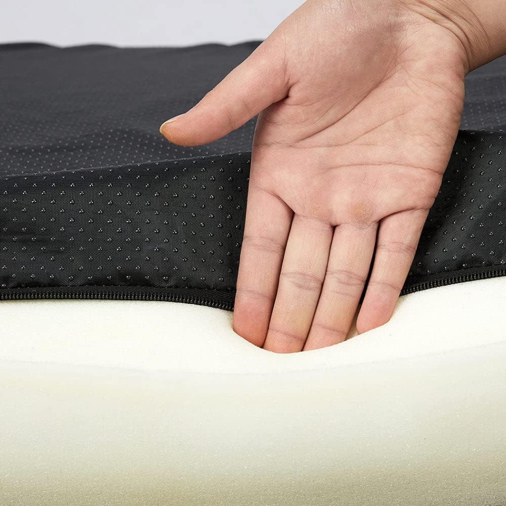 Hand pressing down on a black and white foam mattress topper at Pet Servo