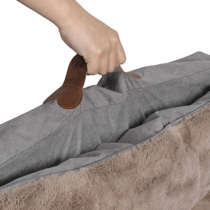 Hand using a leather shoe scraper on a gray fabric surface with a brown fur trim at Pet Servo