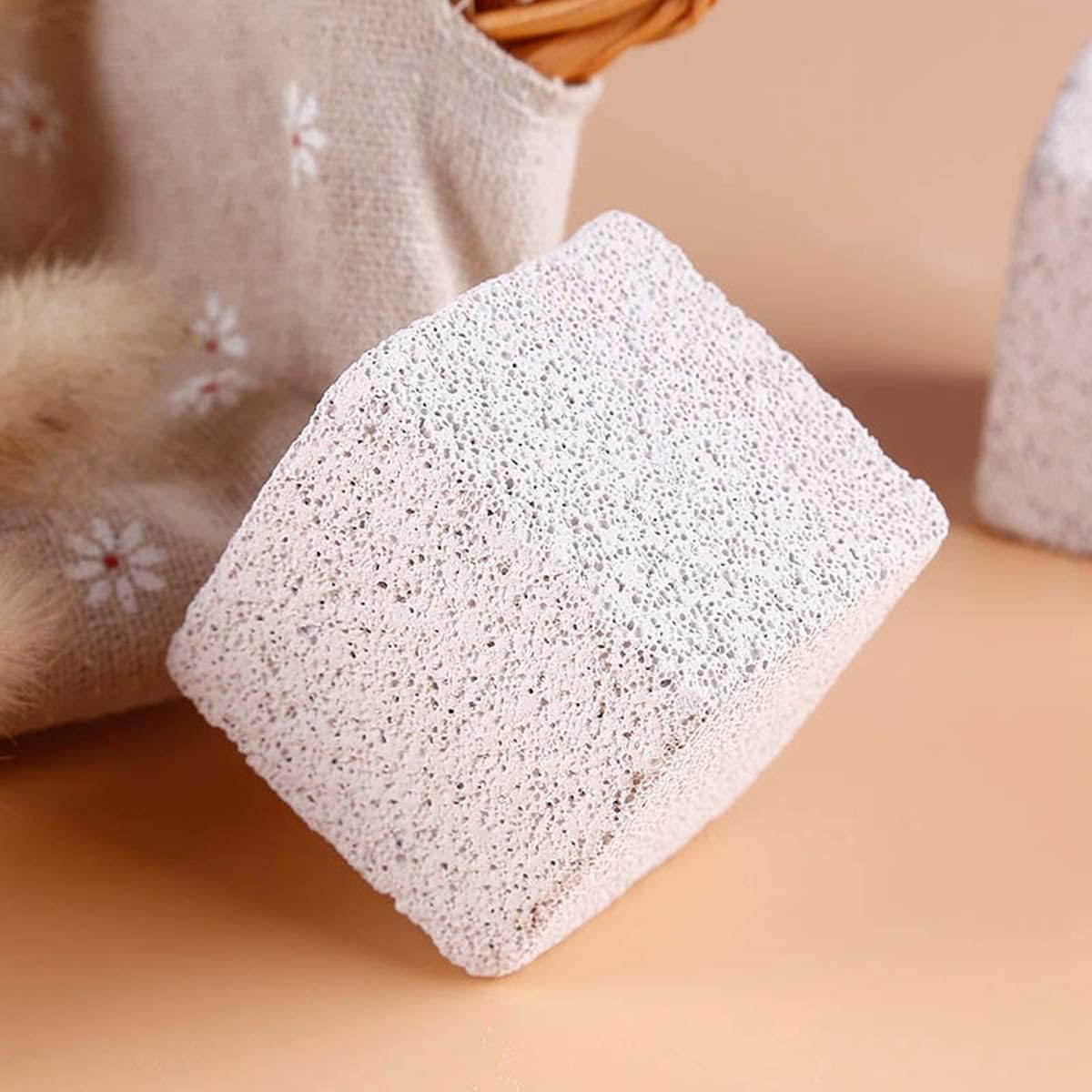Square pumice stone on a beige surface with a floral towel in the background at Pet Servo