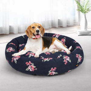 Dog lying on a floral-patterned dog bed in a bright room at Pet Servo