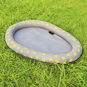 Inflatable pool with yellow paw prints on grass at Pet Servo