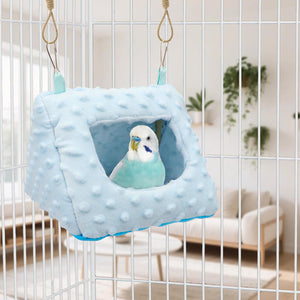 Blue bird nest with a parakeet inside, hanging from a cage at Pet Servo