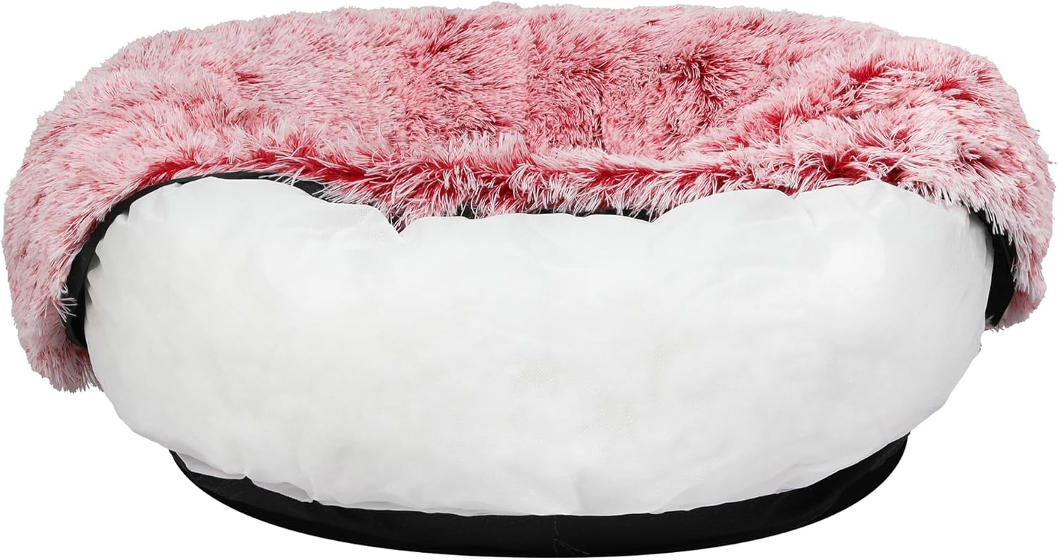A round pet bed featuring a fluffy pink faux-fur top and a white plush cushioned base, with a black outer trim at Pet Servo