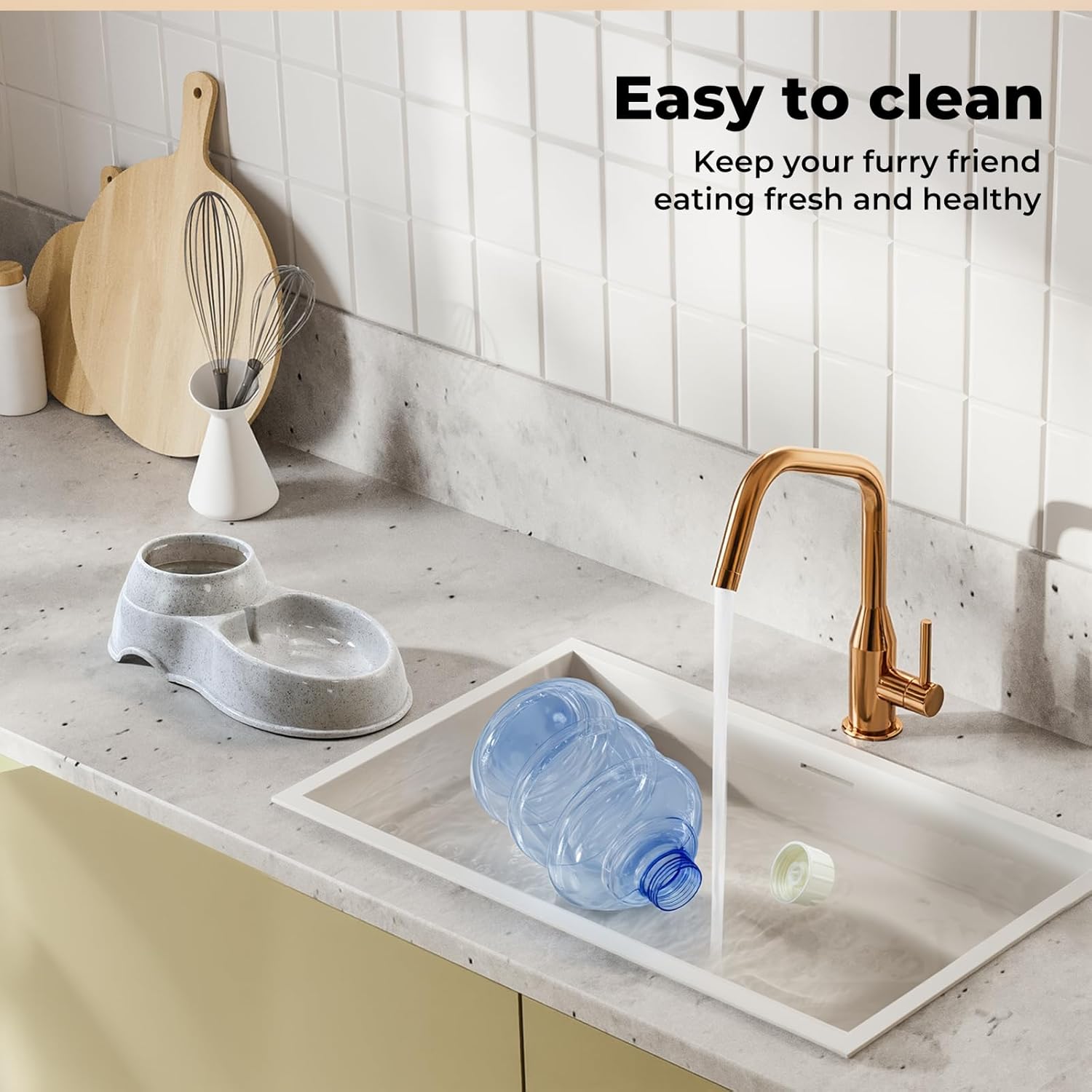 A pet water bowl set shown in a kitchen setting with a marble countertop, white subway tiles, and a running faucet. The set includes a gray double bowl, a white rectangular sink tray, and a blue plastic water bottle at Pet Servo