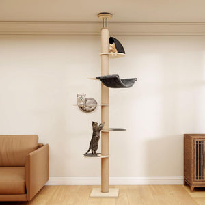 A tall cat tree with multiple levels stands in a living room. Two cats are present: one sitting on the top perch and one climbing on the middle platform at Pet Servo