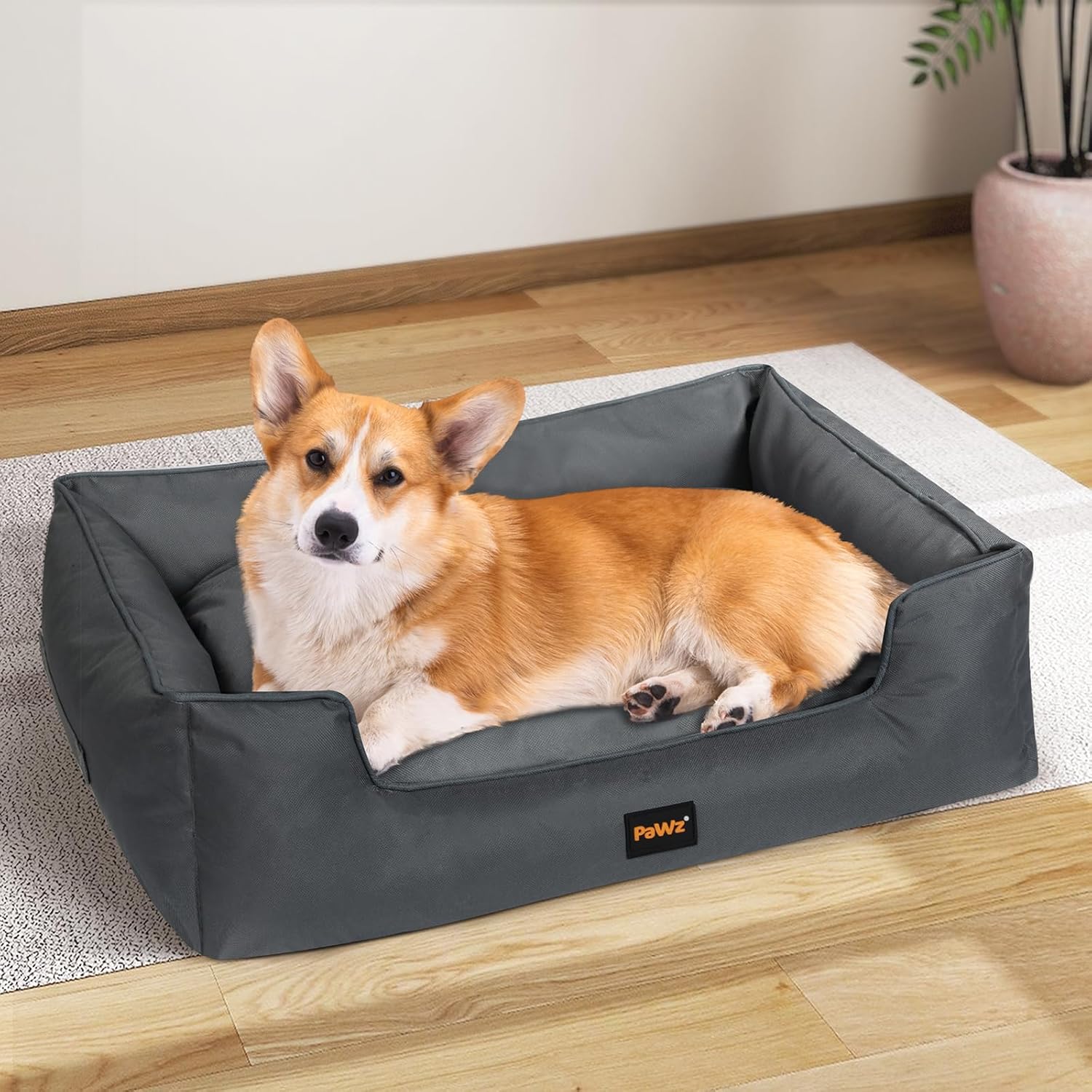 Dog lying on a gray pet bed with a visible brand logo in a home setting at Pet Servo