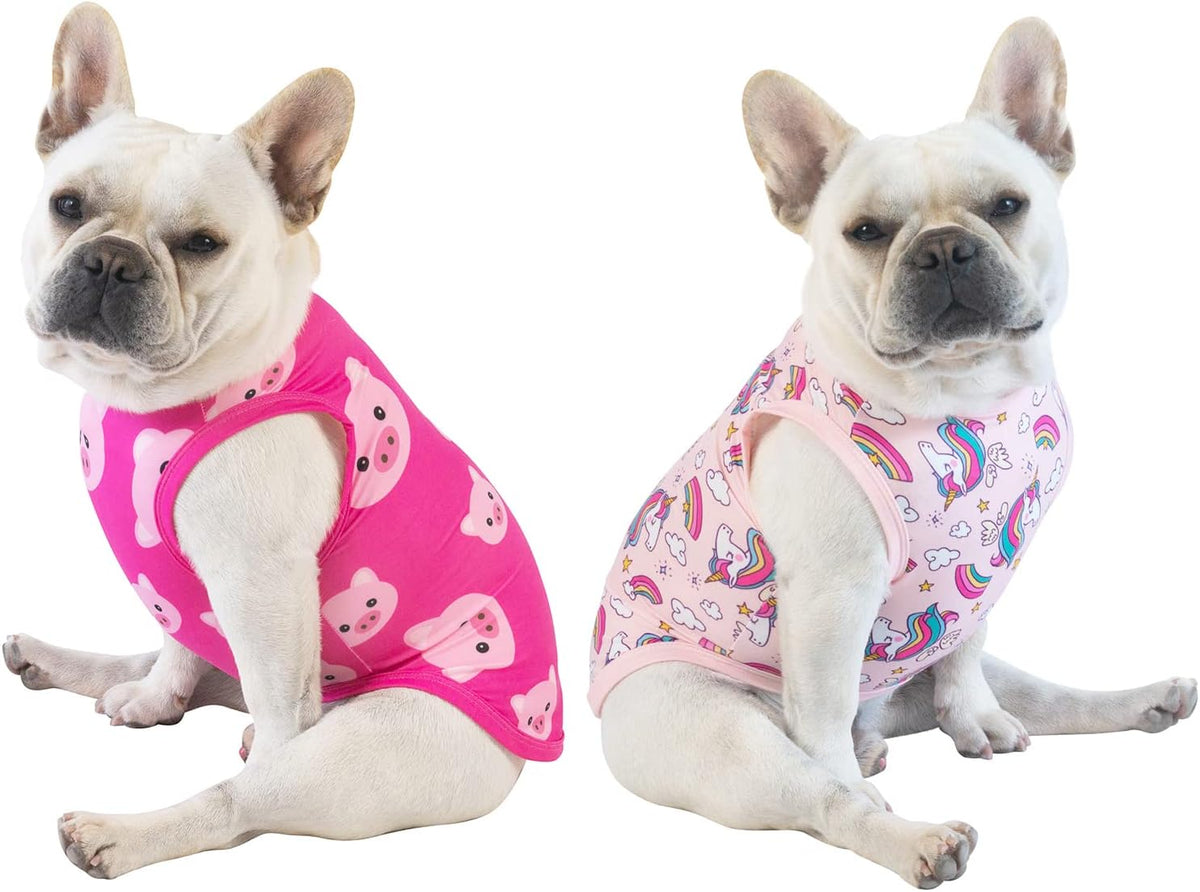 Two dogs wearing pink sleeveless outfits with different patterns on a white background at Pet Servo