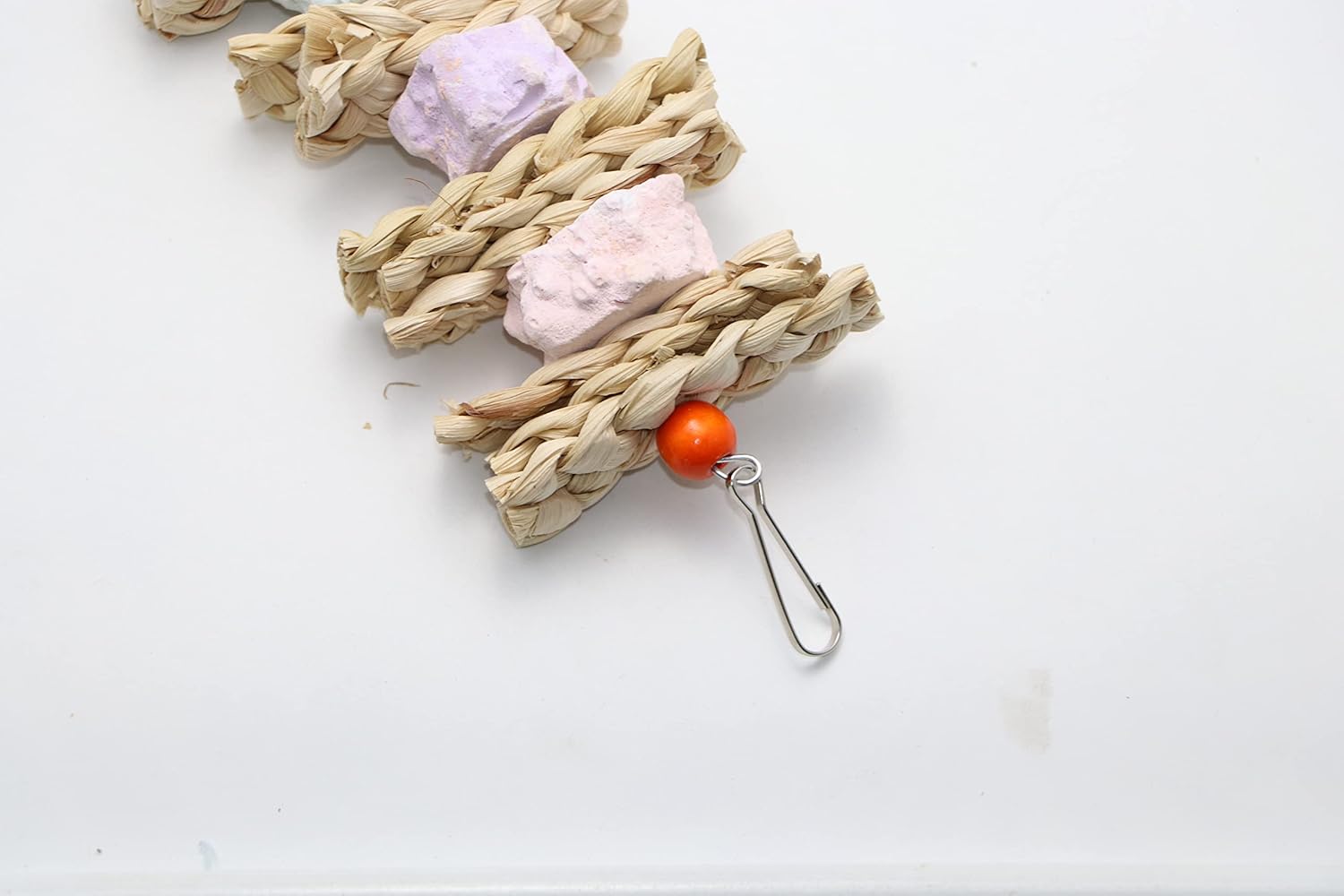Woven cat toy with pink and white catnip balls and an orange bead on a white background at Pet Servo
