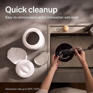 Person cleaning a kitchen sink with easy-to-remove parts and dishwasher-safe bowl on a gray surface.