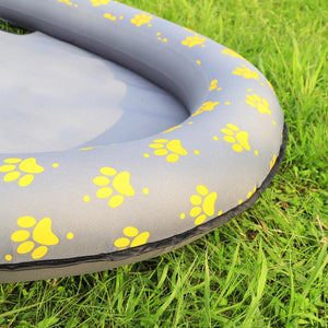 Inflatable pet bed with yellow paw prints on grass at Pet Servo