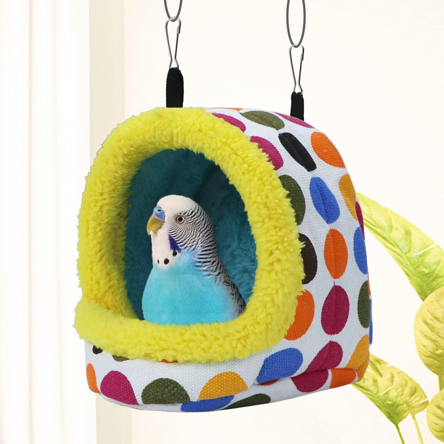 Colorful polka dot pet bed with a parakeet inside, hanging against a white background at Pet Servo