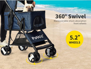 A navy blue pet stroller with a small white dog sitting in the top basket, shown on a sandy beach with ocean water in the background. Text overlays highlight features including '360° Swivel', 'Maneuverable shock absorption front wheels', and '5 at Pet Servo