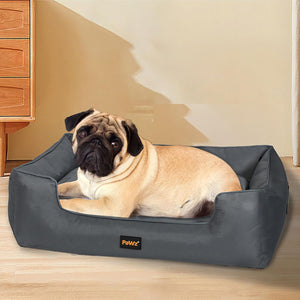 Pug lying on a gray pet bed with 'PaWz' branding in a home setting at Pet Servo