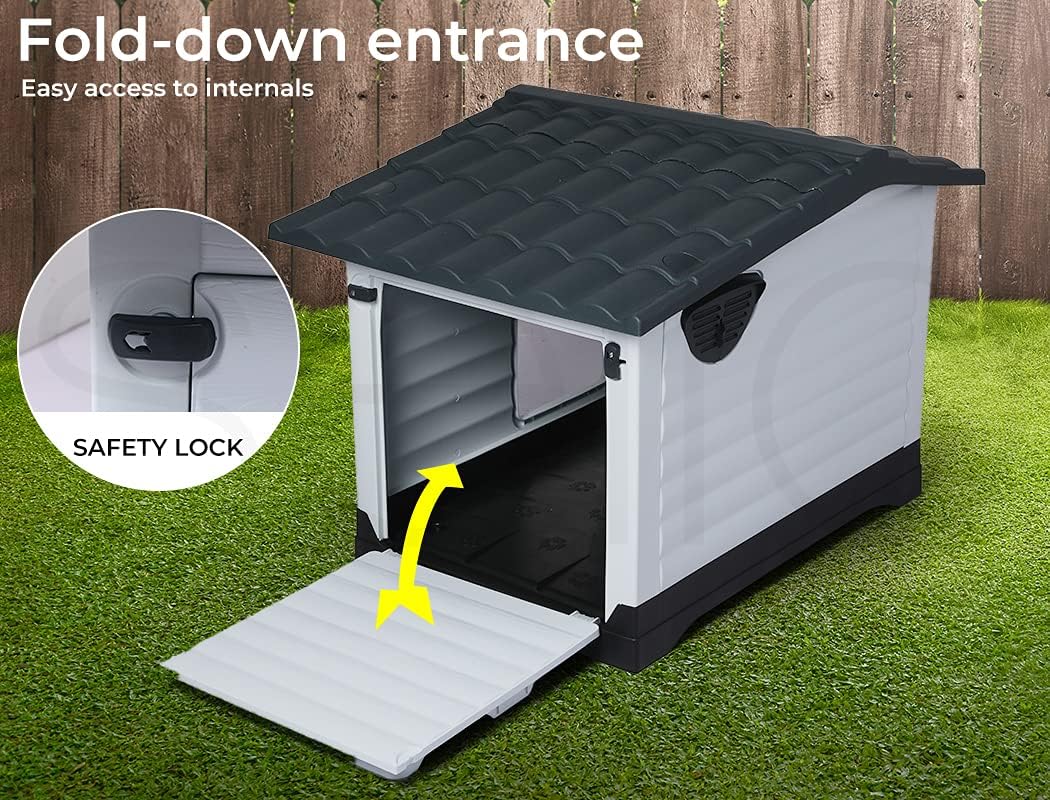 A white and dark gray outdoor doghouse with a fold-down entrance door, shown on artificial grass in front of a wooden fence. The image includes marketing text ('Fold-down entrance', 'Easy access to internals'), a circular inset labeled 'Safety Lock' showing a lock mechanism, and a yellow arrow indicating the door folding down at Pet Servo