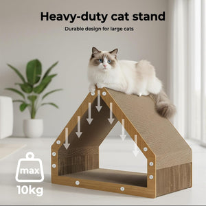 A fluffy white and gray cat sits on top of a house-shaped cat stand made of natural wood and textured scratching material. The scene is a bright indoor room with a potted plant in the background at Pet Servo
