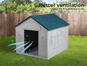 A white outdoor doghouse with a dark teal roof, shown on a green lawn in front of a wooden fence. The image includes text reading 'Better ventilation' and blue airflow graphics near the open doorway to illustrate improved airflow at Pet Servo