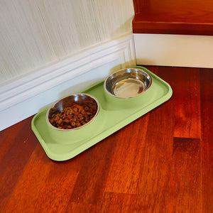 Green pet feeding mat with two metal bowls on a wooden floor at Pet Servo